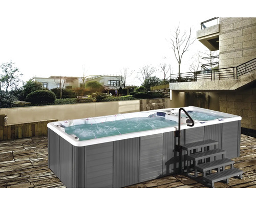 Photo d''un spa de nage extérieur avec escalier et rampe devant un bâtiment.