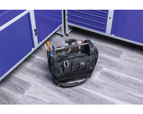 Werkzeugtasche mit Werkzeugen vor blauen Werkstattschränken