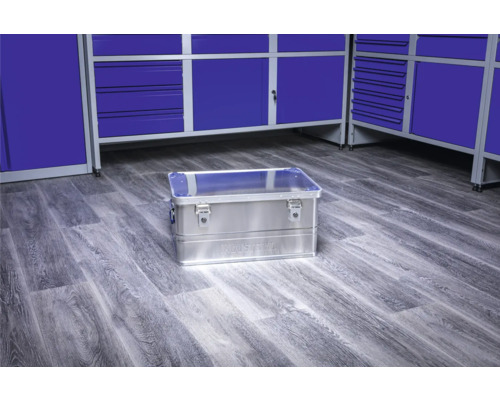 Boîte à outils en aluminium sur un sol d''atelier devant des armoires à outils bleues