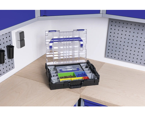 Boîte à outils ouverte avec divers compartiments pour vis et petites pièces sur un établi