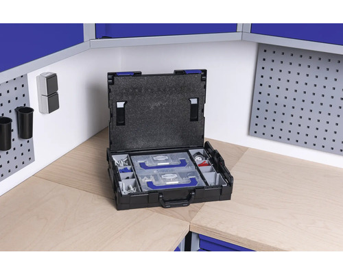 Offener Werkzeugkoffer mit Einsätzen auf einer Werkbank