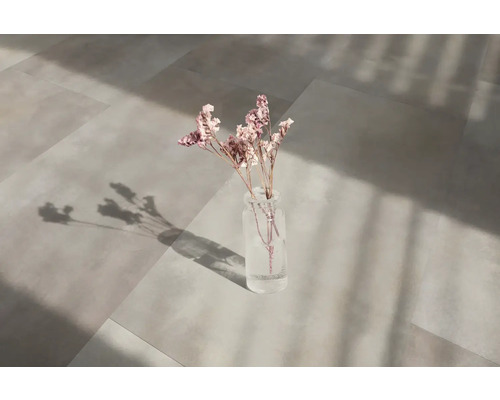 Carrelage de sol avec vase de fleurs sur une surface claire et ensoleillée