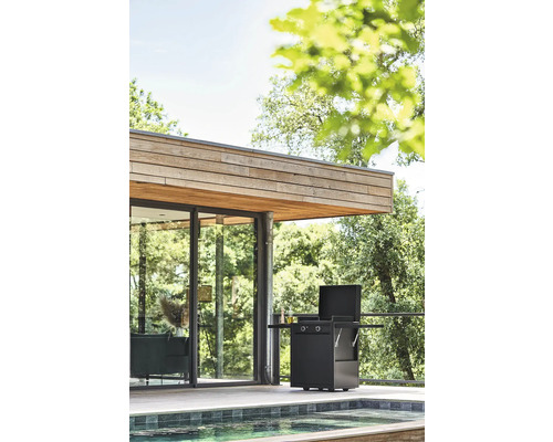 Moderner Aussenbereich mit Grill neben Pool und Haus