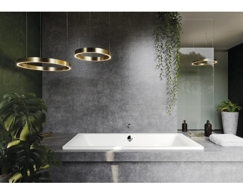 Salle de bain moderne avec baignoire encastrée, carrelage gris et luminaires circulaires.