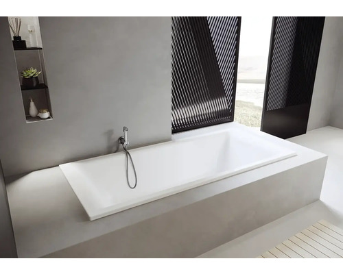 Baignoire rectangulaire encastrée avec douchette à main dans une salle de bains lumineuse.