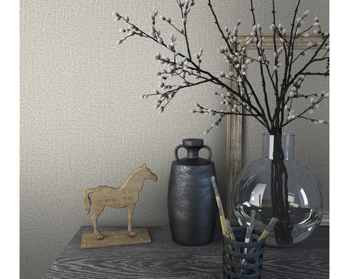 Dekoratives Arrangement mit Holzpferd, Vase und Weidenkätzchenzweigen auf einem Tisch