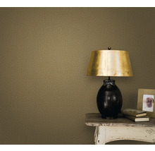 Gros plan d''un mur avec un papier peint textile, une table de chevet, une lampe, un cadre photo et des livres.