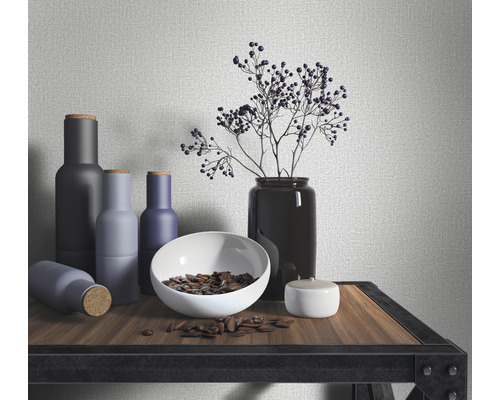 Dekorative Anordnung mit Flaschen, Schale, Pflanze und Dose auf einem Regal