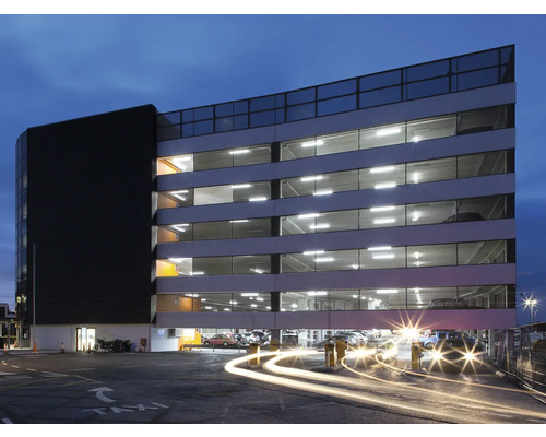 Parking à plusieurs étages avec des plateaux de stationnement éclairés et des voitures