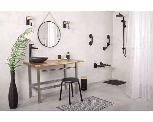 Badezimmer mit Waschtisch, Spiegel, Armaturen, Duschsystem und Haltegriffen für Barrierefreiheit.