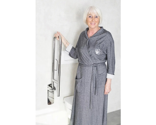 Femme avec une barre d''appui rabattable dans la salle de bain près d''une toilette