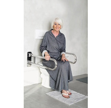 Une femme est assise sur des toilettes avec des barres de maintien rabattables pour le soutien.