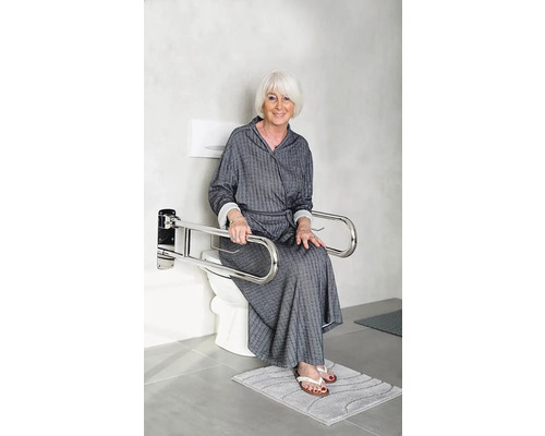 Une femme est assise sur des toilettes avec des barres de maintien rabattables pour le soutien.