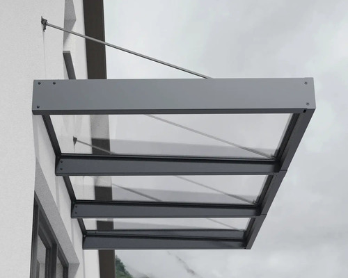 Auvent en verre et métal sur un mur de maison