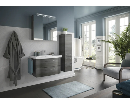 Salle de bains lumineuse avec meuble-lavabo, armoire de toilette, armoire haute, baignoire et fauteuil pour une ambiance moderne.