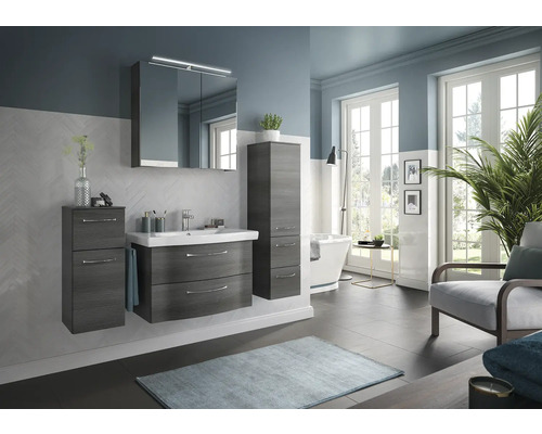 Salle de bains avec meuble-lavabo, armoire de toilette, armoire haute, baignoire et fauteuil.