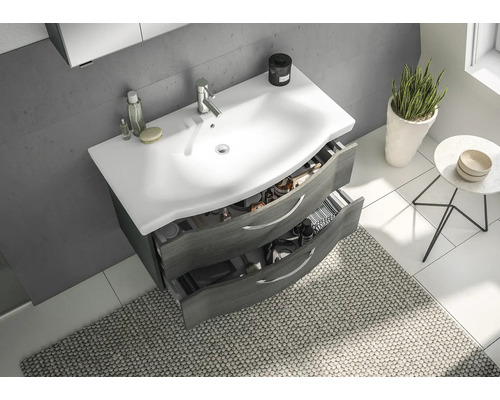 Waschtisch mit offenen Schubladen, Armatur und Badutensilien im Badezimmer