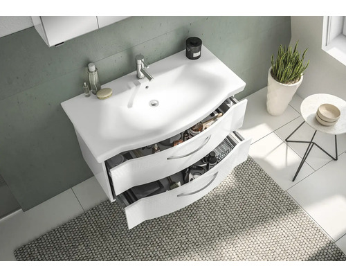 Salle de bains avec meuble sous-vasque, deux tiroirs ouverts, tapis, plante et table d''appoint