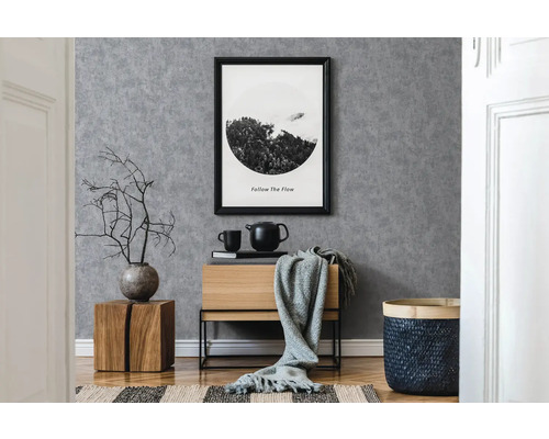 Modernes Interieur mit grauer Tapete, Holzkommode und dekorativen Elementen.