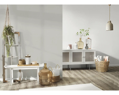 Helles Wohnzimmer mit weissem Sideboard, Dekoration und geflochtenem Korb