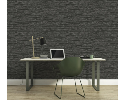 Büro mit Steintapete, Schreibtisch, Lampe, Laptop und Stuhl