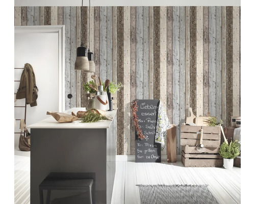 Pièce lumineuse avec îlot de cuisine, caisses en bois et papier peint mural imitation bois