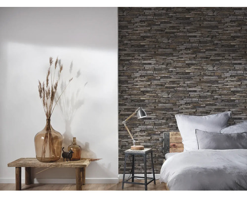 Schlafzimmer mit Steinwandtapete, Holztisch und Dekorationsgegenständen