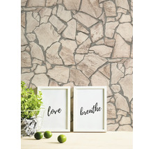 Mur avec motif de pierre et deux cadres photo avec les inscriptions amour et respirer.