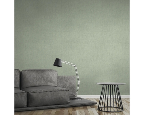 Wohnzimmer mit grüner Textiltapete, Sofa, Lampe und Tisch