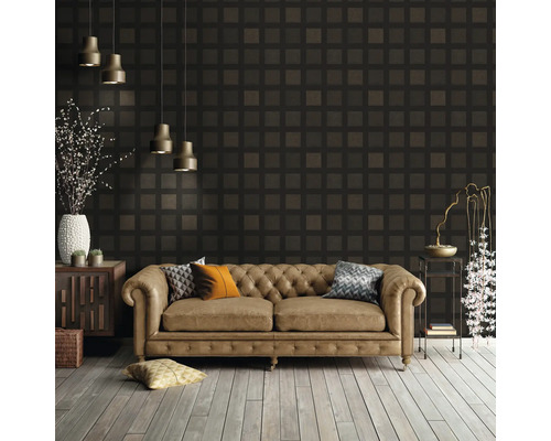 Salon avec canapé en cuir devant un papier peint à motifs