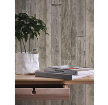 Mur décoratif avec papier peint à panneaux de bois, plante et livres sur une table