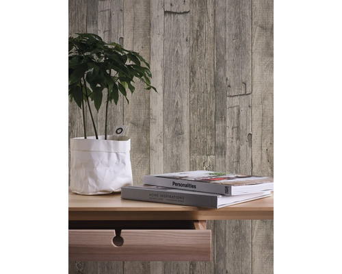 Mur décoratif avec papier peint à panneaux de bois, plante et livres sur une table