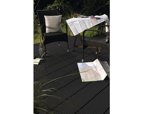 Scène de terrasse avec des meubles en rotin et une carte sur un plancher en bois