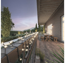 Guirlande lumineuse sur une terrasse avec vue sur le jardin