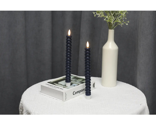 Bougies LED décoratives sur une table avec un vase de fleurs