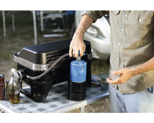 Person schliesst Gasflasche an Gasgrill an