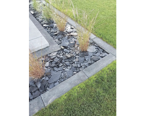 Parterre de jardin avec pierres d''ardoise, bordures de gazon et graminées ornementales