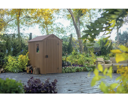 Gartenschuppen aus Kunststoff mit Fenster und Tür auf einer Terrasse im Garten.