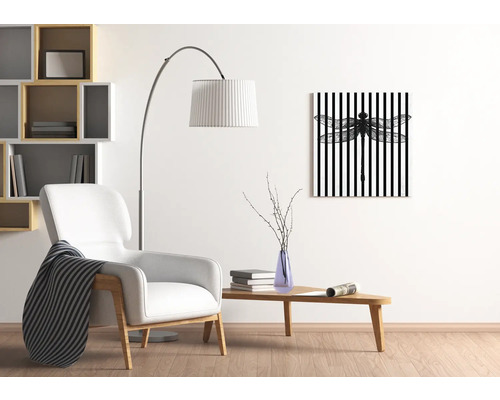 Salon avec fauteuil, lampadaire, table et tableau mural