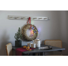Nature morte décorative avec table, chaises, couronne, guirlande lumineuse et porte-manteau