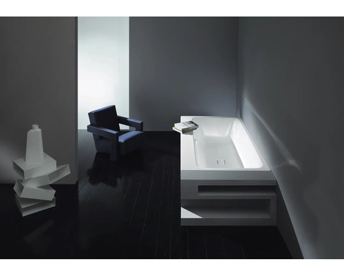 Salle de bain avec baignoire, chaise et décoration sur parquet foncé