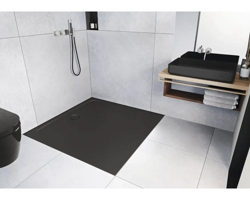 Salle de bain moderne avec receveur de douche plat et carré, lavabo et toilettes.