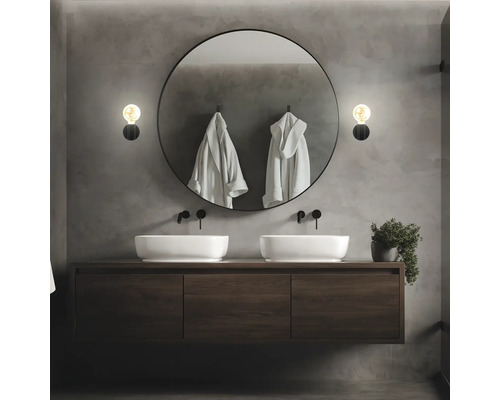 Modernes Badezimmer mit Doppelwaschbecken, rundem Spiegel und Wandleuchten