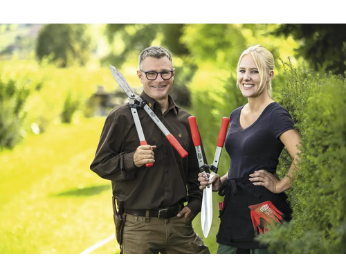 Deux personnes présentent des taille-haies dans le jardin.