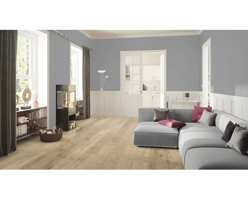 Salon avec canapé, poêle et sol stratifié clair.