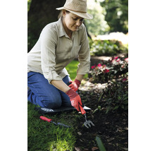 Frau arbeitet im Garten mit Handgeräten und Knieschutz