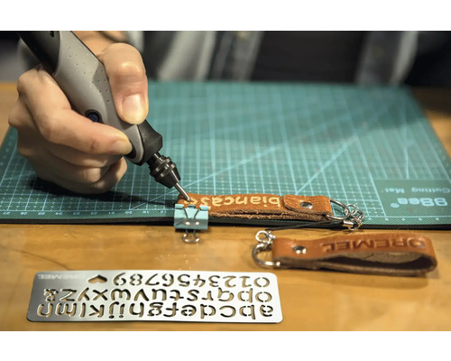 Dremel Gravurwerkzeug beim Gravieren eines Lederanhängers mit dem Namen Bianca, Vorlage für Buchstaben und Zahlen im Bild