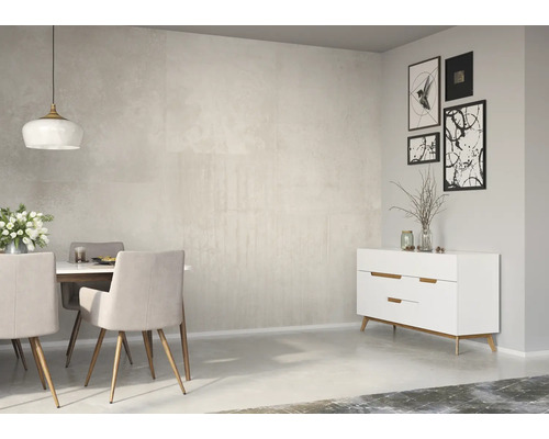 Salle à manger lumineuse avec table, chaises et commode devant un mur sobre