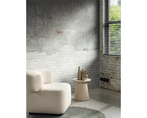 Salon avec fauteuil, table d''appoint et vases décoratifs devant un mur avec un motif de briques