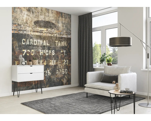 Salon avec papier peint à motifs, fauteuil, lampadaire et commode